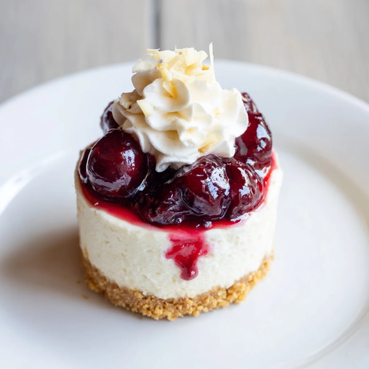 Creamy Kirsch-Rococo mini cheesecakes topped with vibrant cherry compote, ready to enjoy.