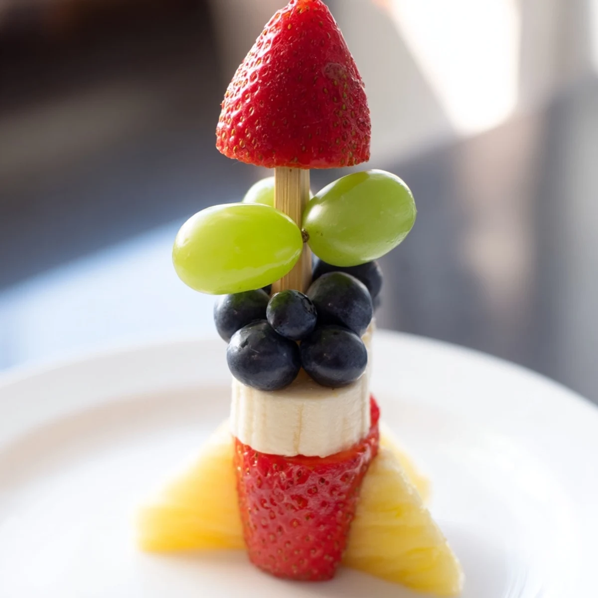 Brightly colored Rocket Ship Fruit Skewers, a fun and delicious snack with strawberries and grapes.