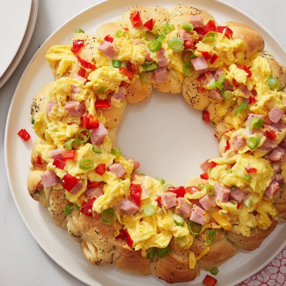 A close-up of the delicious Wreath-Shaped Egg and Ham Bake, showcasing the cheesy, eggy filling baked inside.