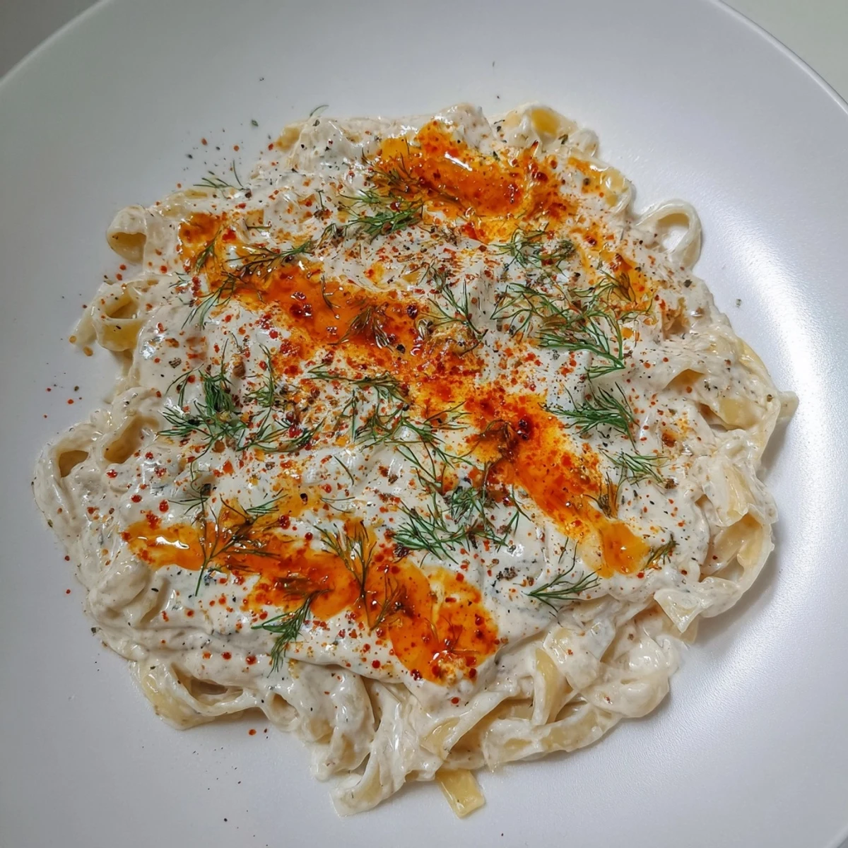 Turkish Pasta swimming in vibrant paprika chili butter, ready to be served.