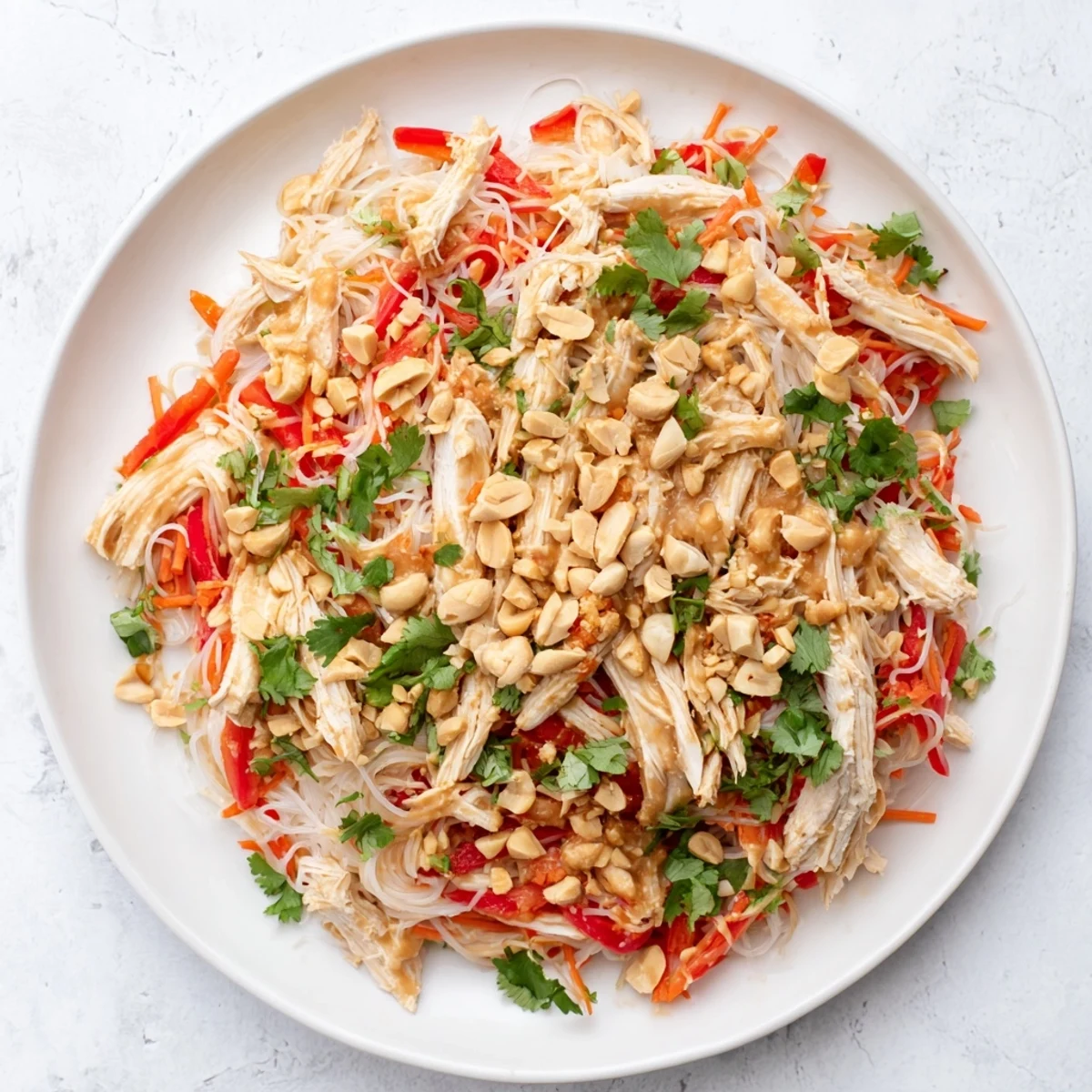 A bowl of flavorful Thai-Inspired Peanut Chicken Pasta, garnished with peanuts and cilantro, perfect for dinner.