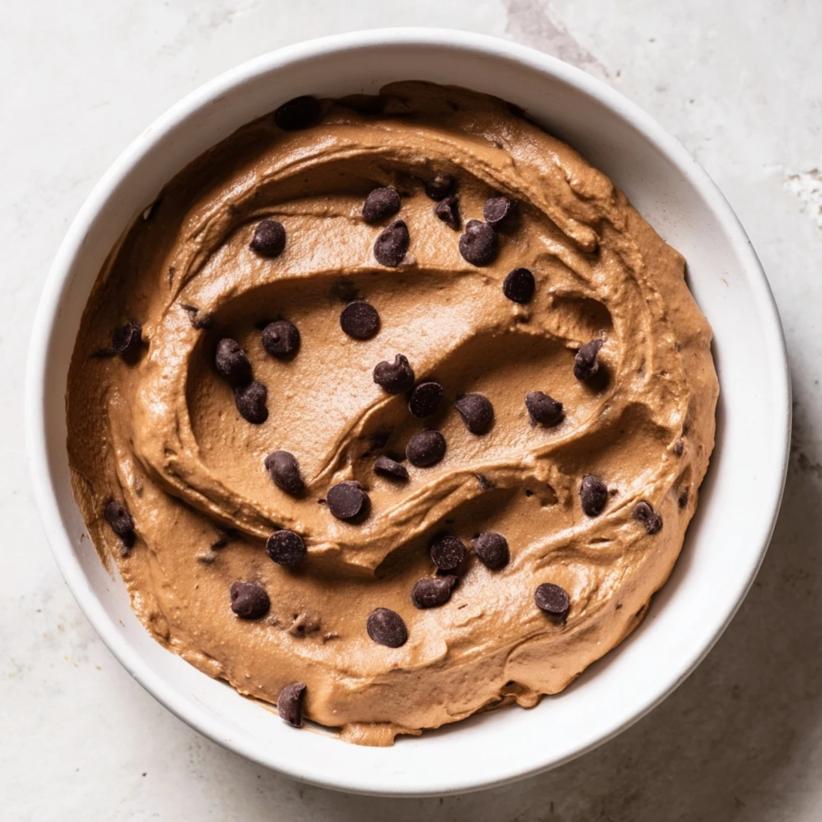 Close-up of smooth, dark chocolate hummus ready to be enjoyed, a sweet and delicious treat.