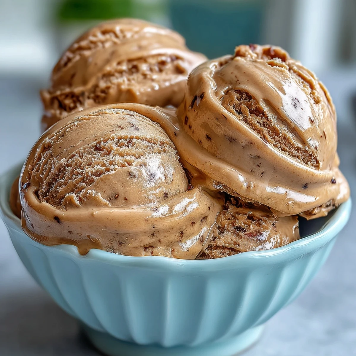 Rich Hojicha Ice Cream in a rustic dish, garnished with a mochi piece and spoon.