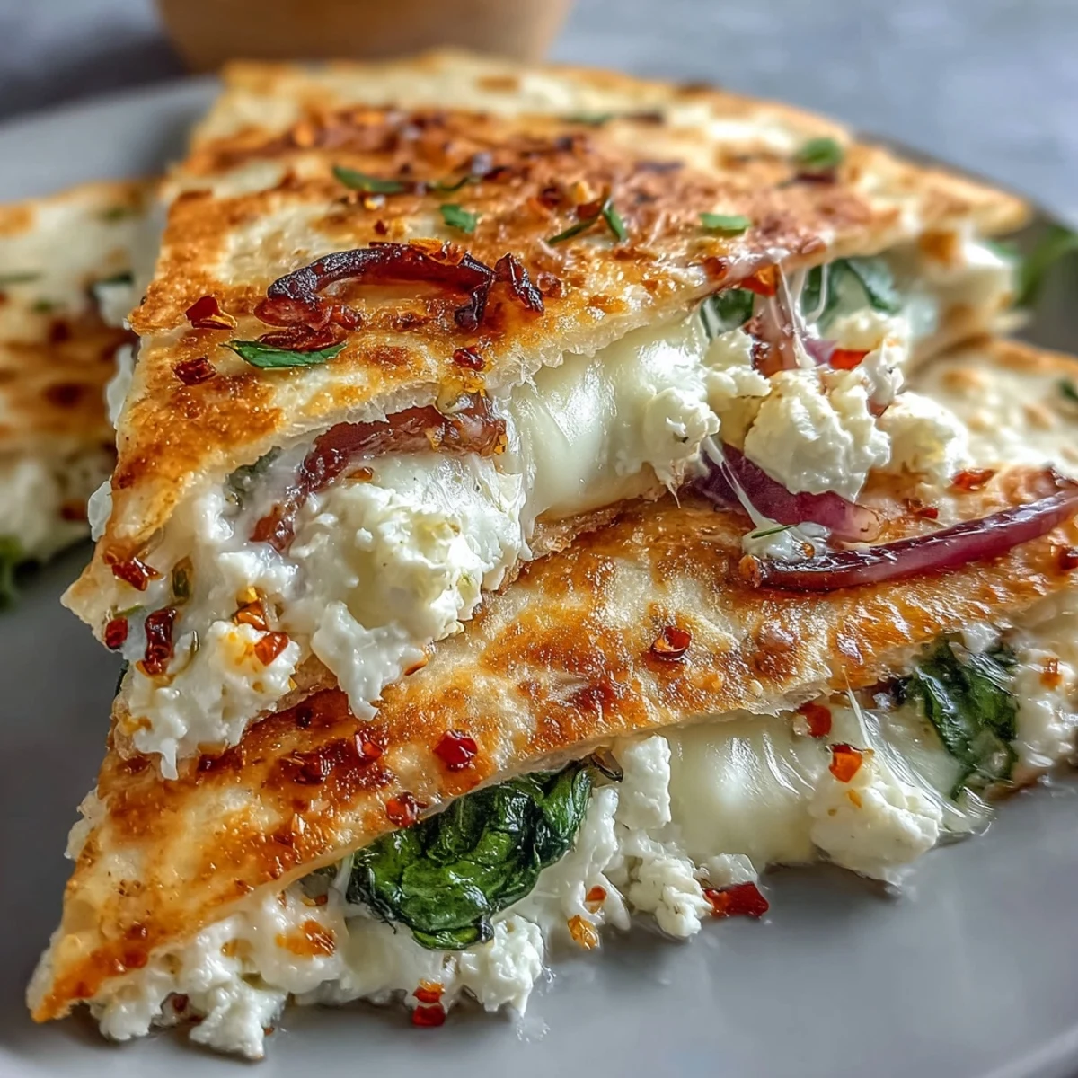 Saftige Mediterranean Quesadillas mit Spinat, Feta, Mozzarella und roter Zwiebel, gestapelt für den schnellen Hunger.