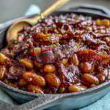 2. Dampfende Schüssel mit herzhaften Navy-Bohnen in süß-rauchiger Sauce, garniert mit knusprigem Speck.  