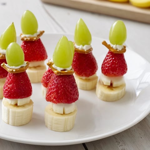 Festliche Elf-Hut Erdbeerspieße mit frischen Erdbeeren, Bananen, und Trauben, eine bunte Leckerei.