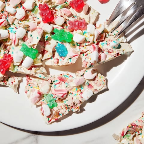 Colorful image of Sweet Treats: Gummy Bears and Candy Canes scattered on white chocolate.