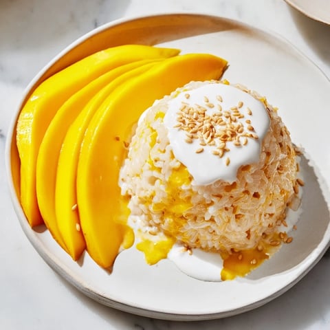 Sweet, juicy mango slices alongside a portion of coconut milk-infused Thai mango sticky rice.