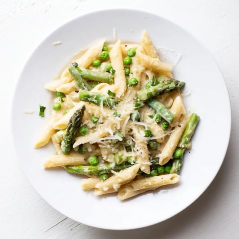 Creamy Garlic Parmesan Spring Vegetable Pasta tossed with fresh asparagus, peas, and green beans.