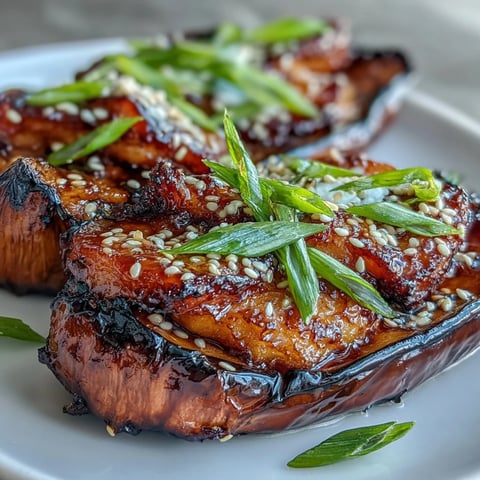 Goldbraun gebratene Miso Glazed Eggplant auf einem Teller, übergossen mit einer glänzenden Würzsauce.