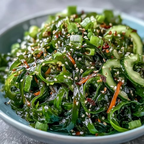 Frische Seaweed Salad Schüssel mit knackigem Wakame, Karottenstreifen und Gurken in einem würzigen Sesam-Ginger-Dressing.  