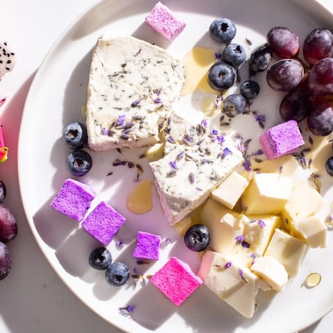 Soft purple hues of a Lavender Haze Dreamscape cheese board, perfect for a gathering, offering a variety of flavors.