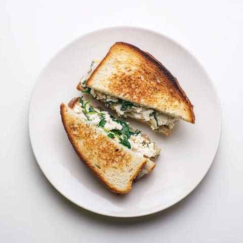 Röstierte Brotseiten des Feta & Spinach Stuffed Grilled Cheese, goldbraun und knusprig, zeigen leicht auslaufenden Käse.