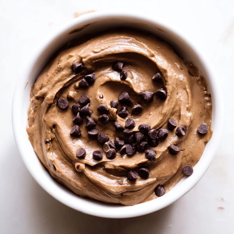 Rich chocolate hummus, the perfect healthy snack, pictured with crunchy pretzel sticks and sliced apples.