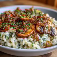 1. Eine cremige Schüssel Risotto mit karamellisierten Zwiebeln und gebratenen Pilzen, garniert mit frischer Petersilie und Parmesan.  