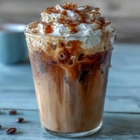 Erfrischender, cremiger Eiskaffee mit echter Vanilleschote und luftiger Kokos-Sahnehaube – perfekt für warme Tage.