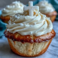 Zarte Vanilla Communion Cupcakes mit einem süßen weißen Fondantkreuz, perfekt für die Feier.